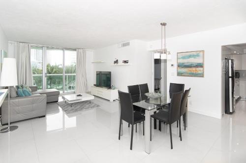 a white living room with a table and chairs at Lovely Beach Apartment by Miami Te Espera- HOLLYWOOD 5U in Hollywood