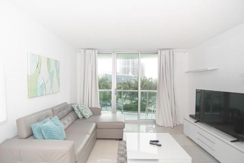 uma sala de estar com um sofá e uma grande janela em Lovely Beach Apartment by Miami Te Espera- HOLLYWOOD 5U em Hollywood
