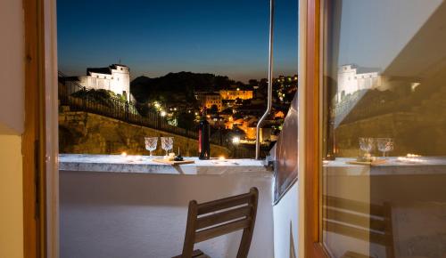 a window with a view of a city at night at Imperia - Chic! place with balcony in Dubrovnik