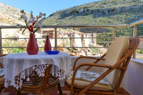 a table with two chairs and a vase with flowers at Sunny Holiday in Sarandë