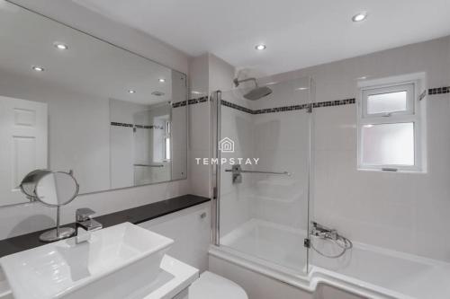 a white bathroom with a sink and a shower at Spacious 5 bed Sunninghill with driveway parking in Ascot