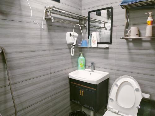ein Badezimmer mit einem WC, einem Waschbecken und einem Spiegel in der Unterkunft Nanjing Tulou Qingdelou Inn in Nanjing
