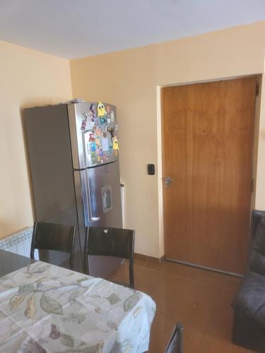 Habitación con mesa, nevera y puerta en Habitacion privada en casa en Ushuaia