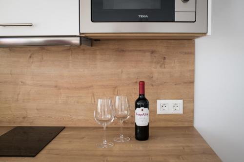 a bottle of wine and two wine glasses on a counter at MAR BIANCO - Gay Men Only in Maspalomas