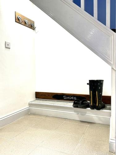 a bench with shoes on it in a hallway at Cosy One Bedroom Apartment in Trowbridge
