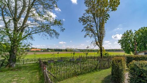 a fence with trees and a field in the background at Die Idyllische - Ferienwohnung mit Garten und Sauna in Kleve