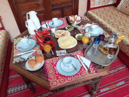 a coffee table with breakfast foods and drinks on it at Riad Sesame in Marrakesh