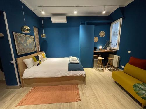 sypialnia z niebieskimi ścianami, łóżkiem i kanapą w obiekcie Apartamento Opera Suite AIDA Madrid Palacio Real w Madrycie