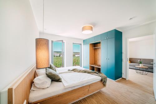 a bedroom with a bed and blue cabinets at Zeit bei Sauerweins in Palzem