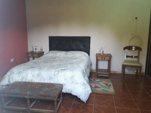 een slaapkamer met een bed en 2 tafels en een stoel bij Sueño Bonito in San Andrés de Giles