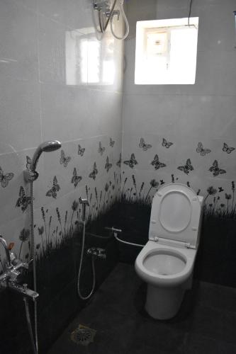 a bathroom with a toilet with butterflies on the wall at DIAMOND HILL VIEW in Ketti