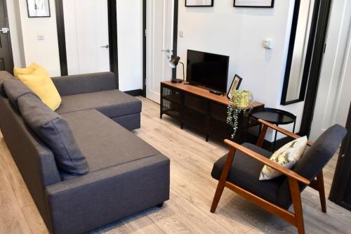 a living room with a couch and a television at The Copperfield Apartment - Broadstairs Central - By Goldex Coastal Breaks in Kent