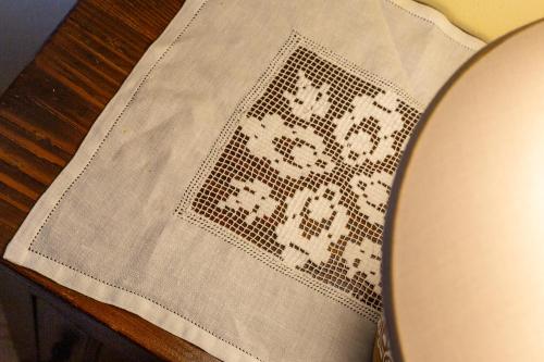 a table with a white cloth with a pattern on it at Affittacamere Is Coronas in Ìsili