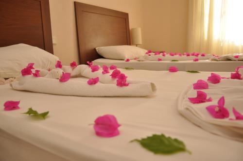 a group of four beds with pink flowers on them at Siesta Beach Apartment in Gümbet