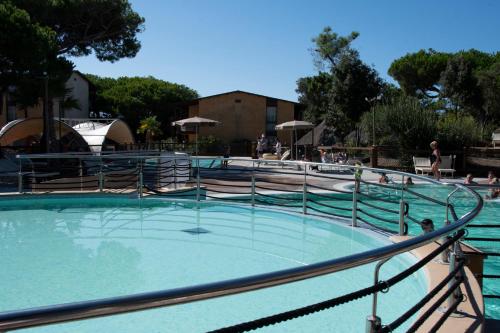 a large pool of water with people in it at Canado Club Family Village in Marina di Castagneto Carducci