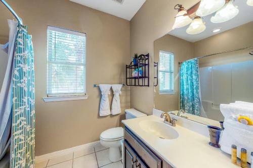 een badkamer met een wastafel, een toilet en een spiegel bij Emerald View in Destin