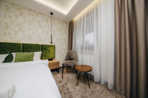 1 dormitorio con 1 cama, 1 mesa y 1 silla en Boutique Luxury Apartments en Kragujevac