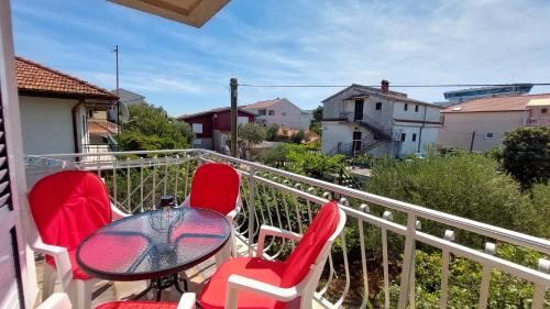 een tafel en stoelen op een balkon met uitzicht bij Apartments Gardijan in Vodice
