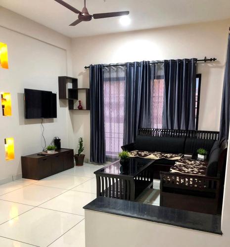a living room with a couch and a tv at Urbane Cove in Trivandrum