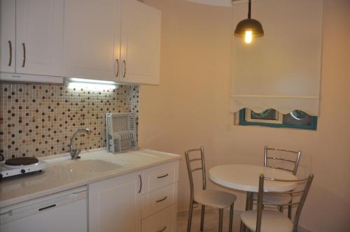 a kitchen with a sink and a table and chairs at Siesta Beach Apartment in Gümbet
