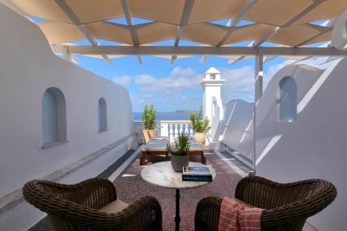 a patio with chairs and a table and a lighthouse at Aneroussa Beach Hotel in Batsi