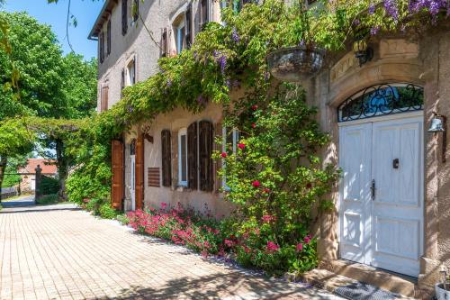 a building with a blue door and flowers on it at Le Clos d'Albray - Chambres d'hôtes et gite in Comps-la-Grand-Ville