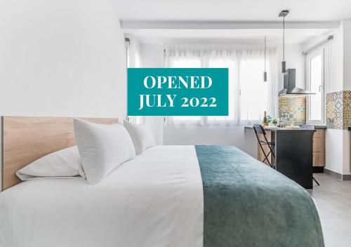 Un dormitorio con una cama y un cartel que lee "Open July" en Open Sea Suites, en Las Palmas de Gran Canaria