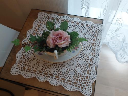 a vase with a pink flower on a table at Aux vignes in Wissembourg
