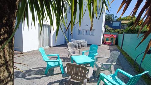 un patio con sillas, mesas y una palmera en Casa en Bosque Peralta Ramos en Mar del Plata