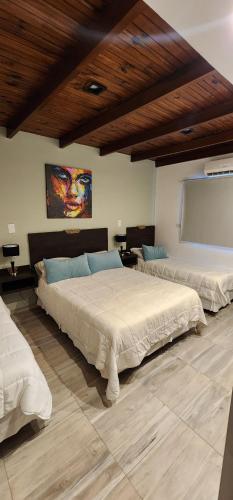 パソ・デ・ロス・リブレスにあるNomades Apartamentosの木製の天井のベッドルーム1室(ベッド2台付)