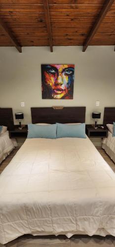 - une chambre avec un grand lit blanc orné d'une peinture murale dans l'établissement Nomades Apartamentos, à Paso de los Libres