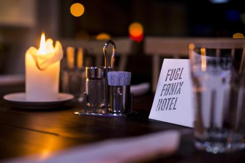 a table with a candle and a sign on it at Fugl Fønix Hotel in Etnesjøen