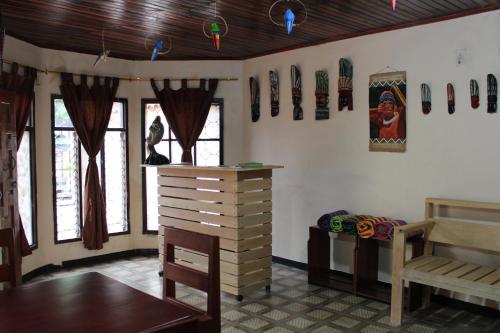 Habitación con cama, mesa y ventanas. en Hipilandia Amazonas Hostel, en Leticia