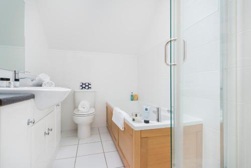 a bathroom with a toilet and a sink and a shower at Harlyn lodge Hot Tub Lodge at Retallack Resort in Saint Columb Major