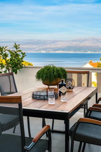 a wooden table on a patio with a view of the ocean at Apartments Tomy in Sutivan