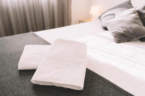 a bed with two white towels on top of it at Home Málaga in Málaga