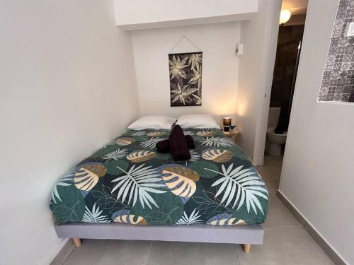 a bed in a small room with a large bed sidx sidx at Studio jungle chic in Le Tampon