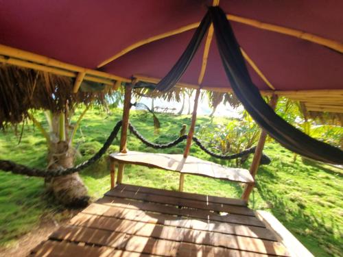 a porch swing with a hammock under a tent at Derek's Place Eco-Lodge in Little Corn Island