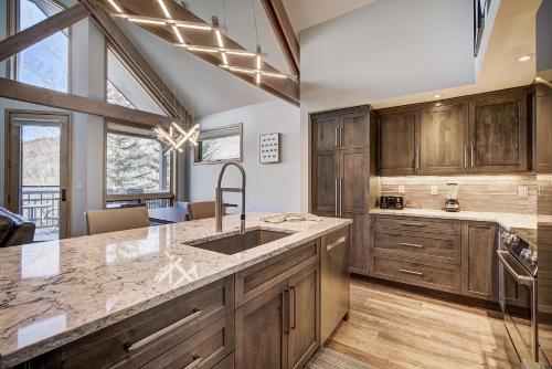 eine Küche mit Holzschränken und einem Waschbecken in der Unterkunft Three-Bedroom Townhouse in Beaver Creek