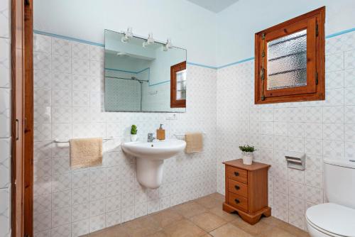 uma casa de banho com um lavatório, um WC e um espelho. em Villa Esplendor em Son Bou