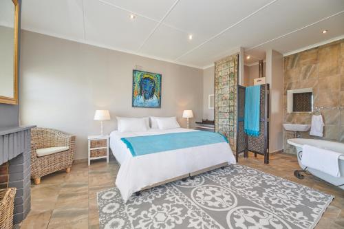 1 dormitorio con 1 cama extragrande y baño en Land's Edge Eco Friendly Cottages and Apartments, en Struisbaai