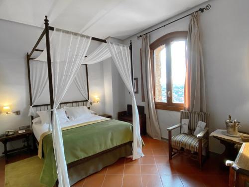 sypialnia z łóżkiem z baldachimem i krzesłem w obiekcie Parador de Cardona w mieście Cardona