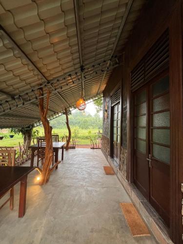 a porch of a house with benches and a tree at Ceylon Resort in Wilpattu