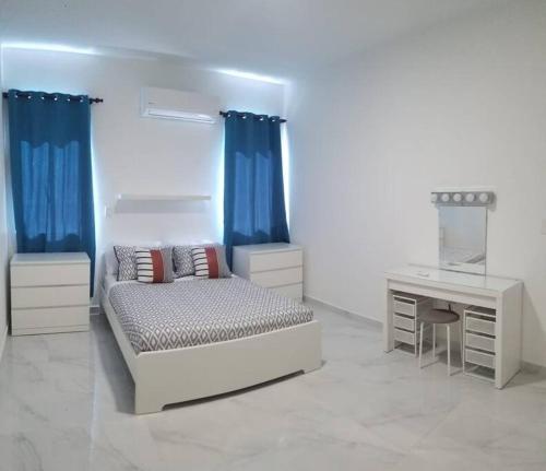 a white room with a bed and a desk and a bed and a desk at Villa en Plantation, Puerto Plata in Muñoz