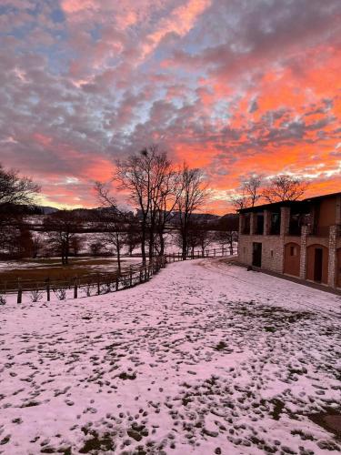 a snow covered field with a sunset in the background at Agriturismo Casale Montebello in Monteleone di Spoleto