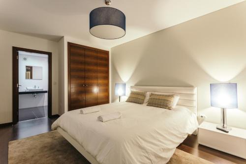 a bedroom with a large white bed with two lamps at Best Houses 23: Stunning Apartment, Great Location in Ferrel