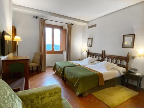 a hotel room with a large bed and a chair at Parador de Cardona in Cardona