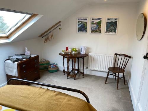 a bedroom with a bed and a table and a chair at North View B&B in Penrith