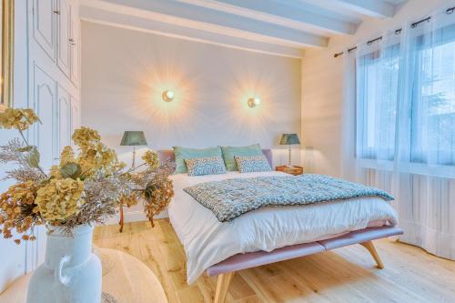 - une chambre avec un lit et un vase avec des fleurs dans l'établissement Villa Bassin D'Arcachon 8 personnes, à La Teste-de-Buch
