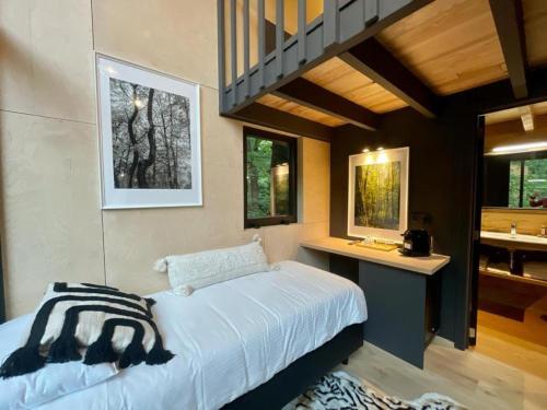 1 dormitorio con cama, escritorio y lavamanos en Utopia Village - Art & Nature Lodges en Jurbise